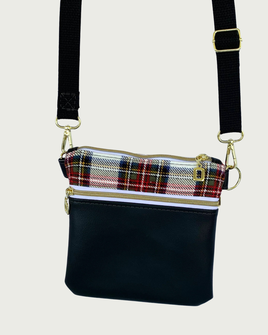 Handcrafted classic red, black, and white plaid crossbody bag with black faux-leather accents, gold-tone hardware throughout including zipper details on top closure and pocket, and a black adjustable, detachable cotton webbing shoulder strap, shown on a light gray background.
