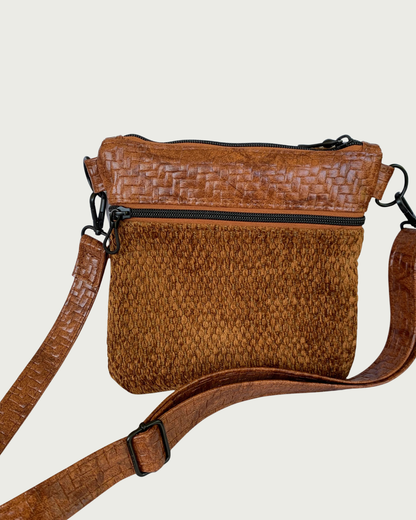 Handmade crossbody bag of brown chenille fabric with brown textured faux leather accents including an adjustable and detachable shoulder strap. Matt black hardware throughout as is on the zippered pocket and the top zippered closure with rope zipper pulls.