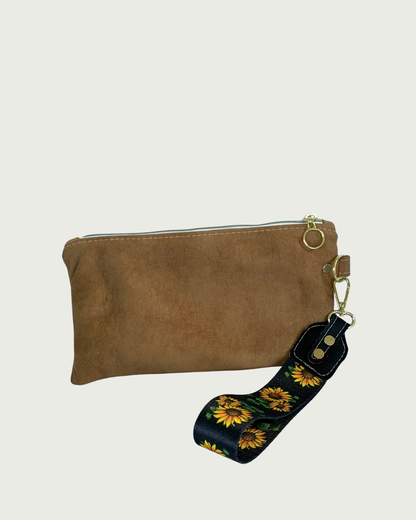 Handmade brown faux suede wristlet with wide sunflower detachable strap and gold hardware including a round ring for a zipper pull.