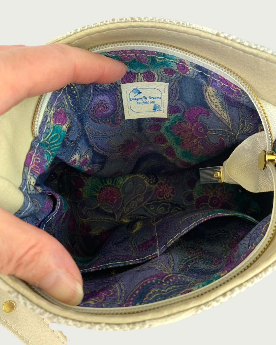 A handcrafted shoulder bag . Closeup view of interior lining with 2 slip pockets.