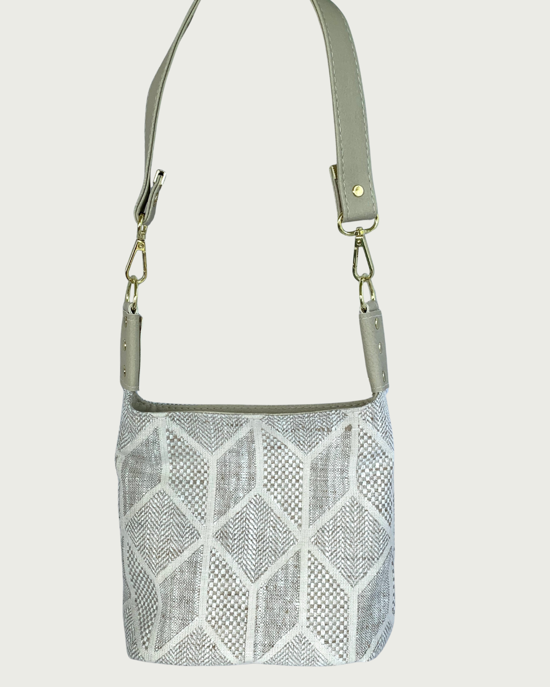 Handcrafted chevron slouchy shoulder bag in neutral colors with beige vinyl strap and trim and gold hardware.
