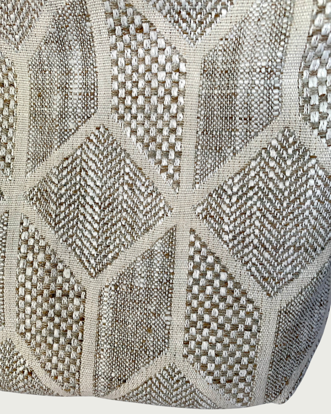 A closeup view of a neutral-colored chevron pattern on repurposed upholstery fabric sample.