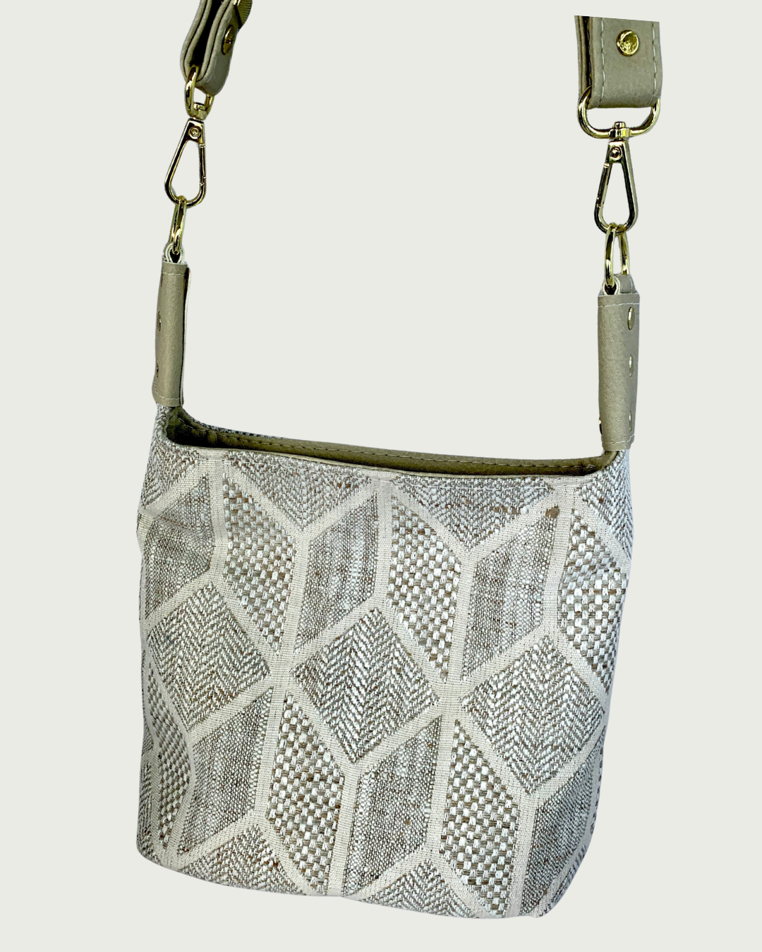 Handcrafted chevron slouchy shoulder bag in neutral colors with beige vinyl strap and trim. Closeup view.