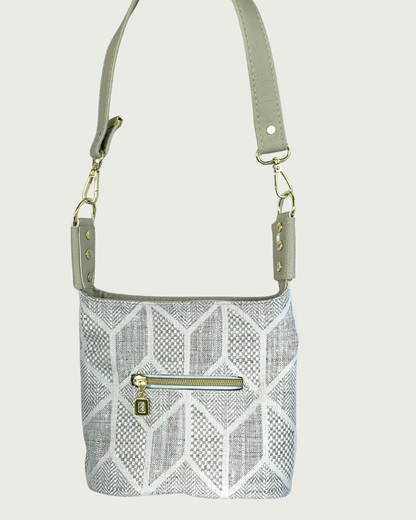 Handcrafted chevron slouchy shoulder bag in neutral colors with beige vinyl strap and trim. Small external zipper pocket.