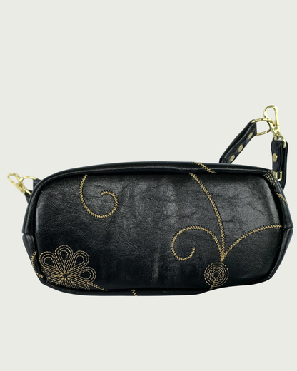 Handcrafted black vinyl slouchy shoulder bag bottom view showing the decorative gold stitching.