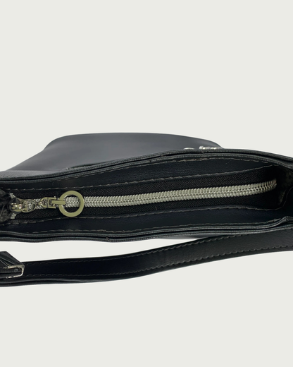 Handcrafted black vinyl slouchy shoulder bag with view of the top closure of a black zipper with nickel teeth and a nickel, dangling circle zipper pull.