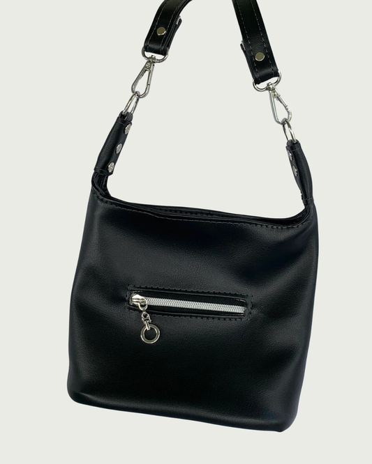 Handcrafted black vinyl slouchy shoulder bag with small exterior zippered pocket, nickel hardware, and detachable strap.