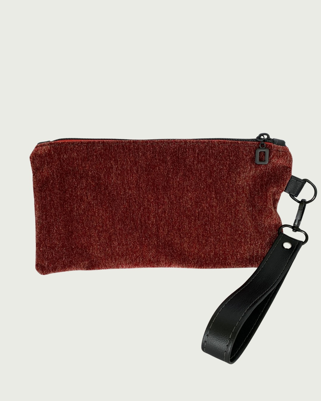 Handcrafted merlot chenille-like polyester wristlet wallet featuring a detachable, black faux leather wrist strap and matt black hardware including an open square top zipper of burgundy zipper tape.