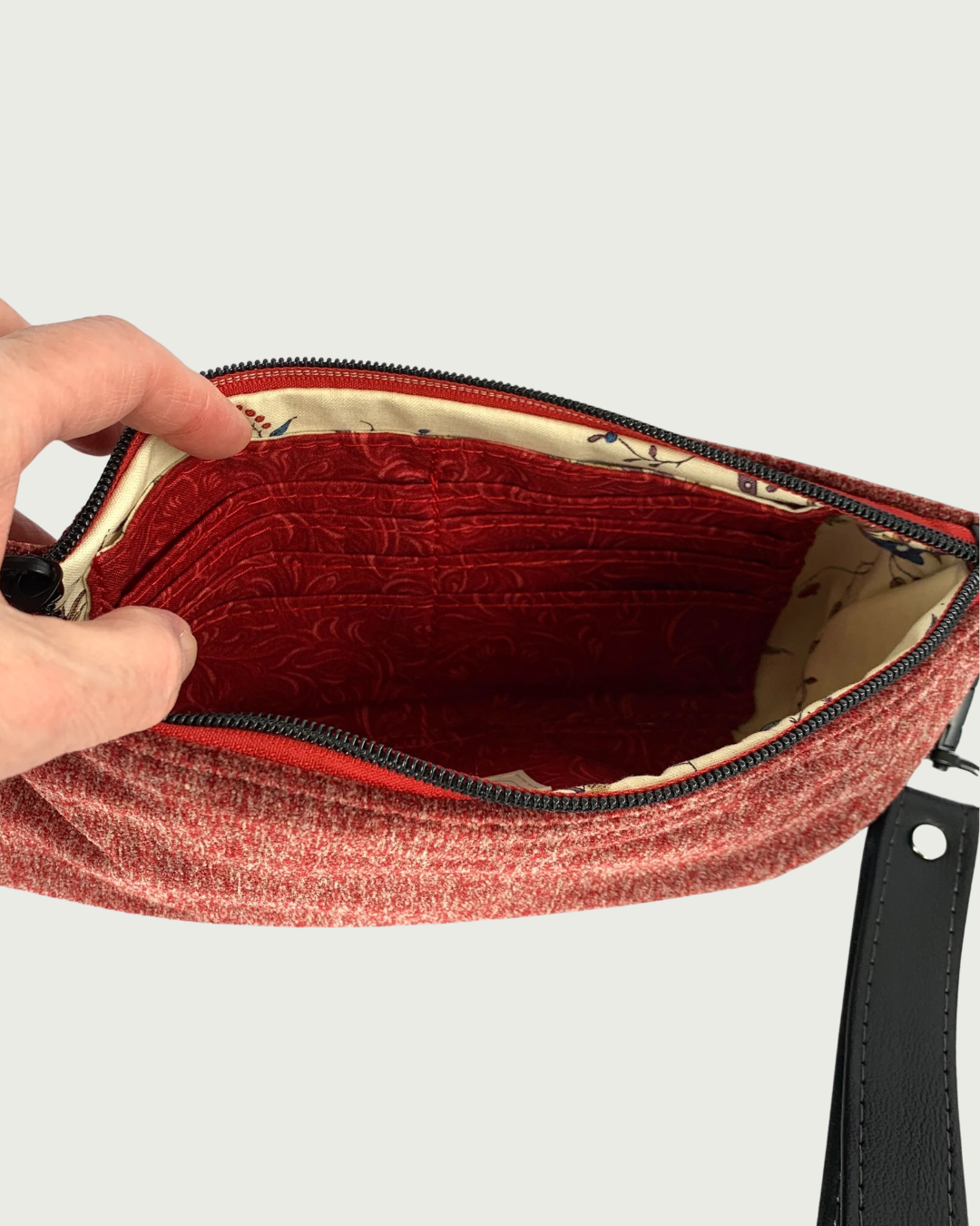 Handcrafted merlot chenille-like polyester wristlet wallet interior of coordinating solid and print fabric and one side features a built-in 8-card slot. A detachable faux leather wrist strap with gunmetal rivet is shown.