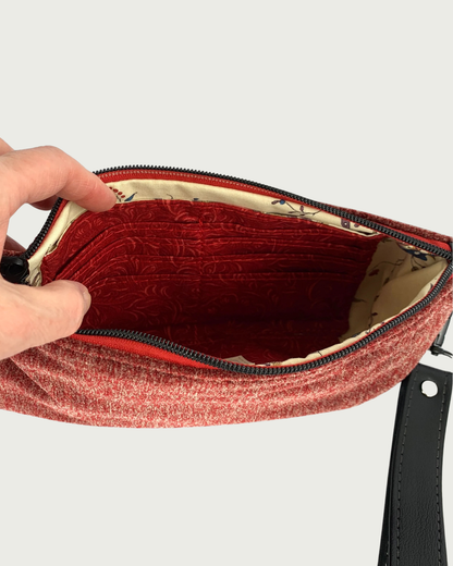 Handcrafted merlot chenille-like polyester wristlet wallet interior of coordinating solid and print fabric and one side features a built-in 8-card slot. A detachable faux leather wrist strap with gunmetal rivet is shown.