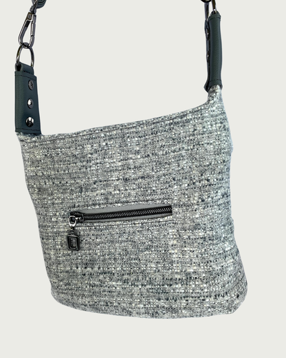 Gray wool-like shoulder bag with gray vinyl strap connectors, a small zippered pocket, and gunmetal hardware.