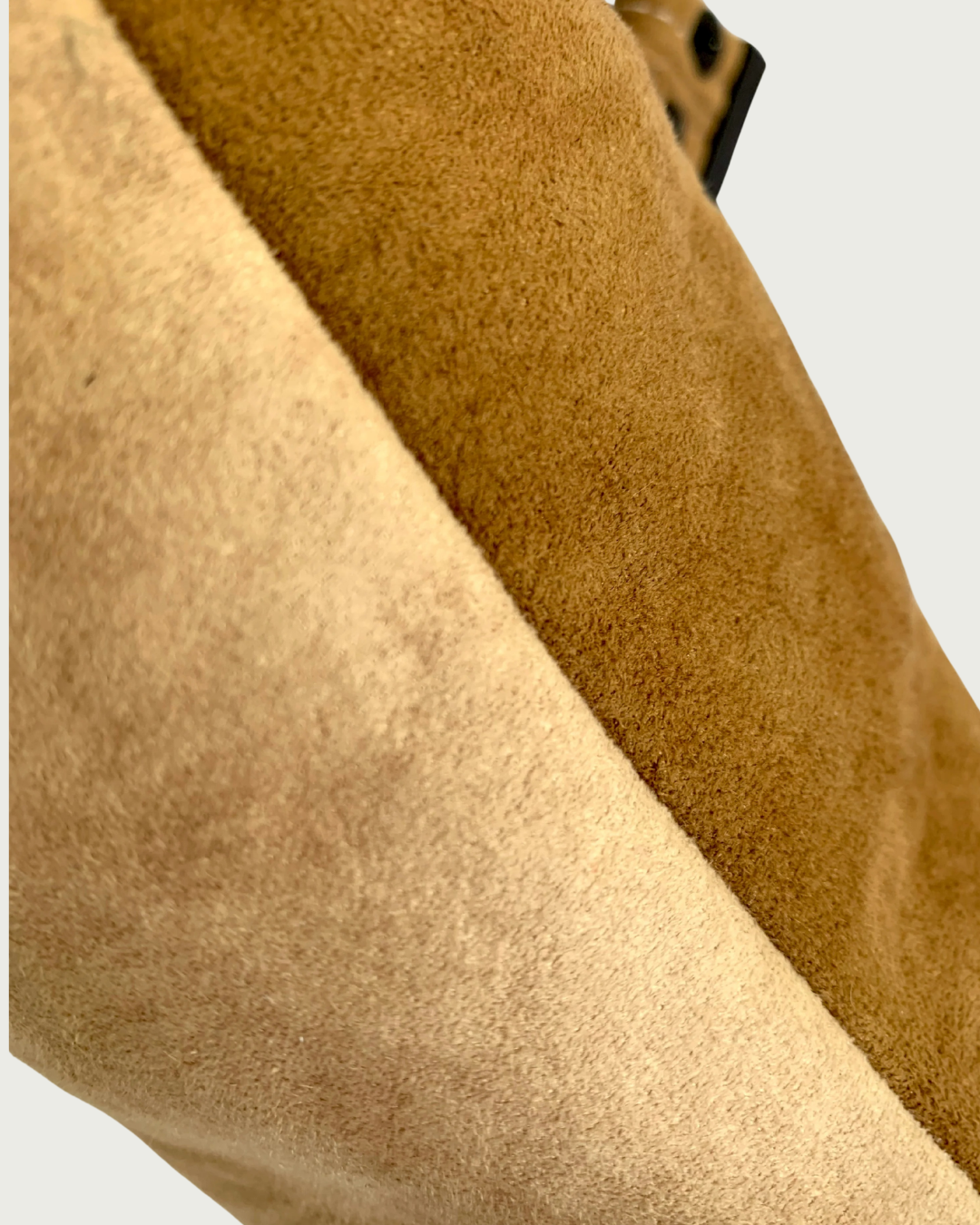 Closeup view of a faux suede two toned handcrafted shoulder bag.