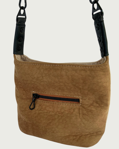 A 2-toned  brown faux suede shoulder bag with black faux-leather strap connectors as seen from front or back-wearer's choice.