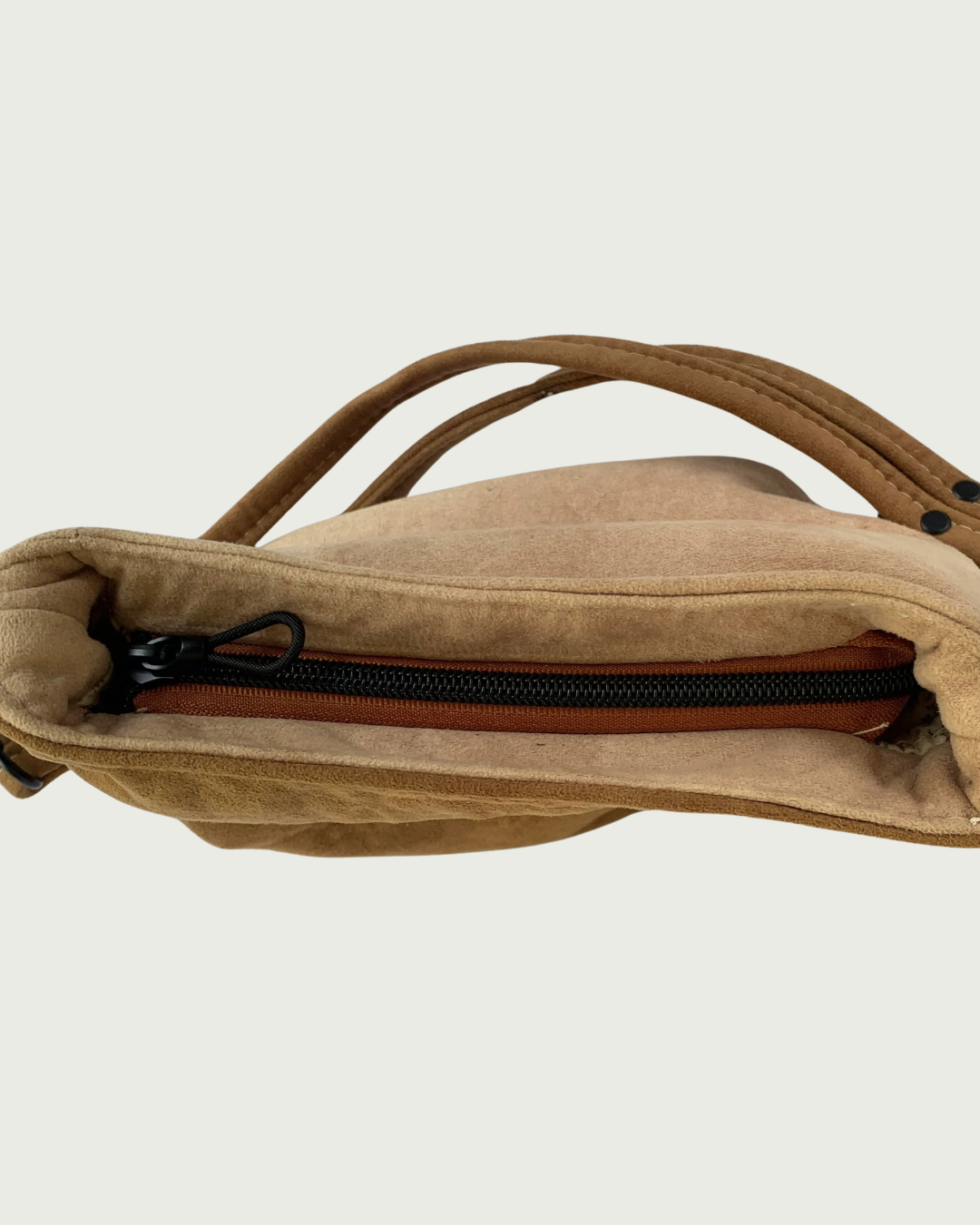 A 2-toned brown faux suede shoulder bag  with a closeup view of the top recessed zipper.