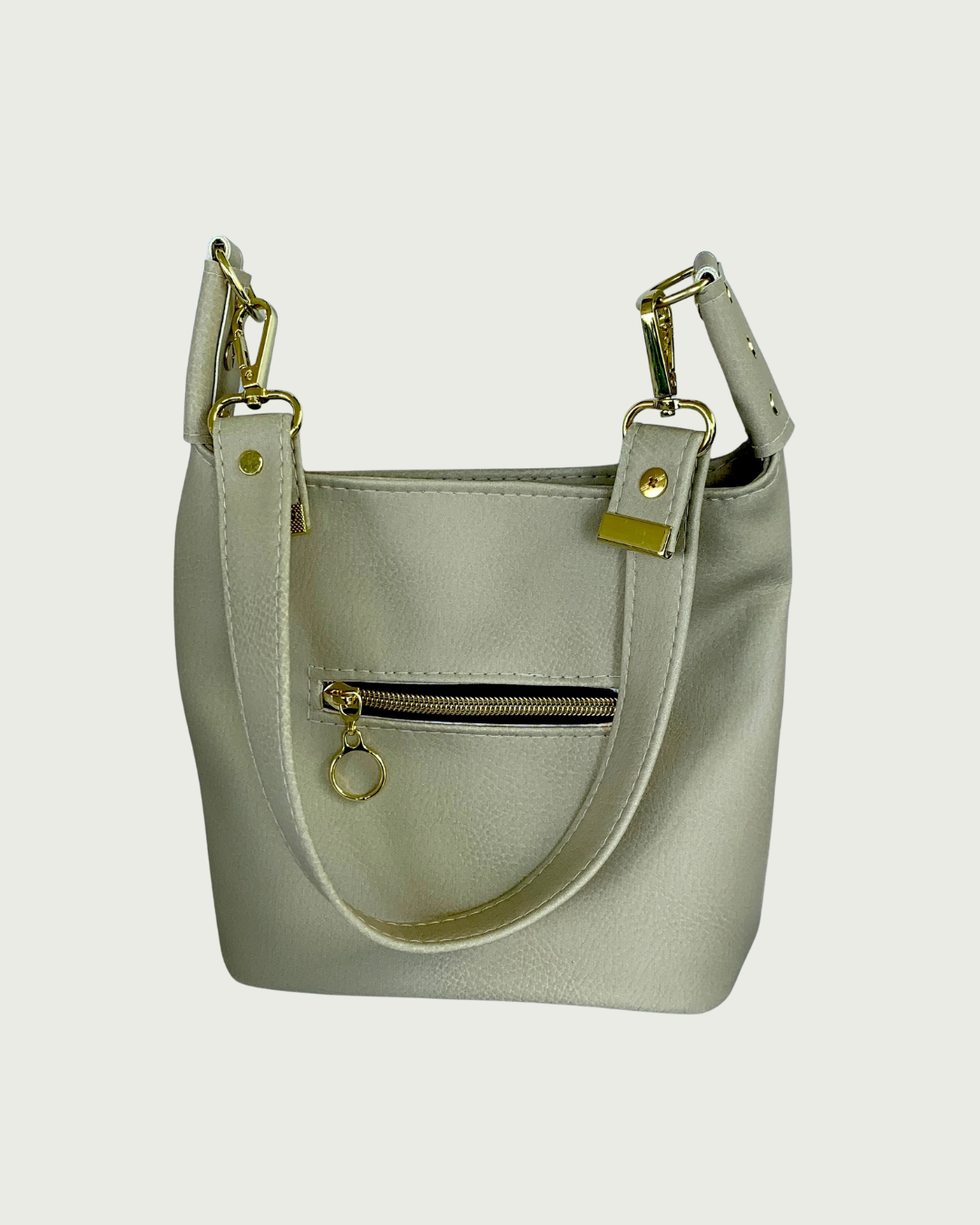 A solid beige faux leather slouchy  shoulder bag with small exterior zippered pocket as seen from front or back-wearer's choice.