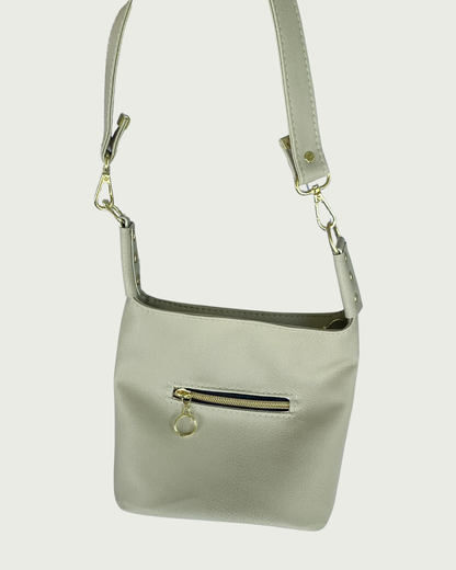 A solid beige faux leather shoulder bag with small exterior zippered pocket as seen from front or back-wearer's choice.