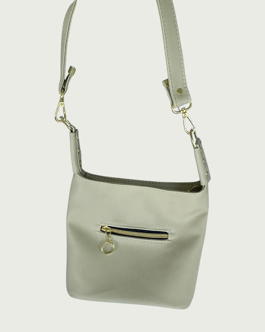 A solid beige faux leather shoulder bag with small exterior zippered pocket as seen from front or back-wearer's choice.