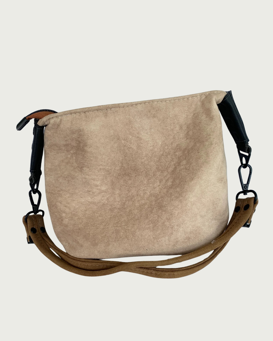 A tan suede shoulder bag with a brown  strap and matt black hardware.